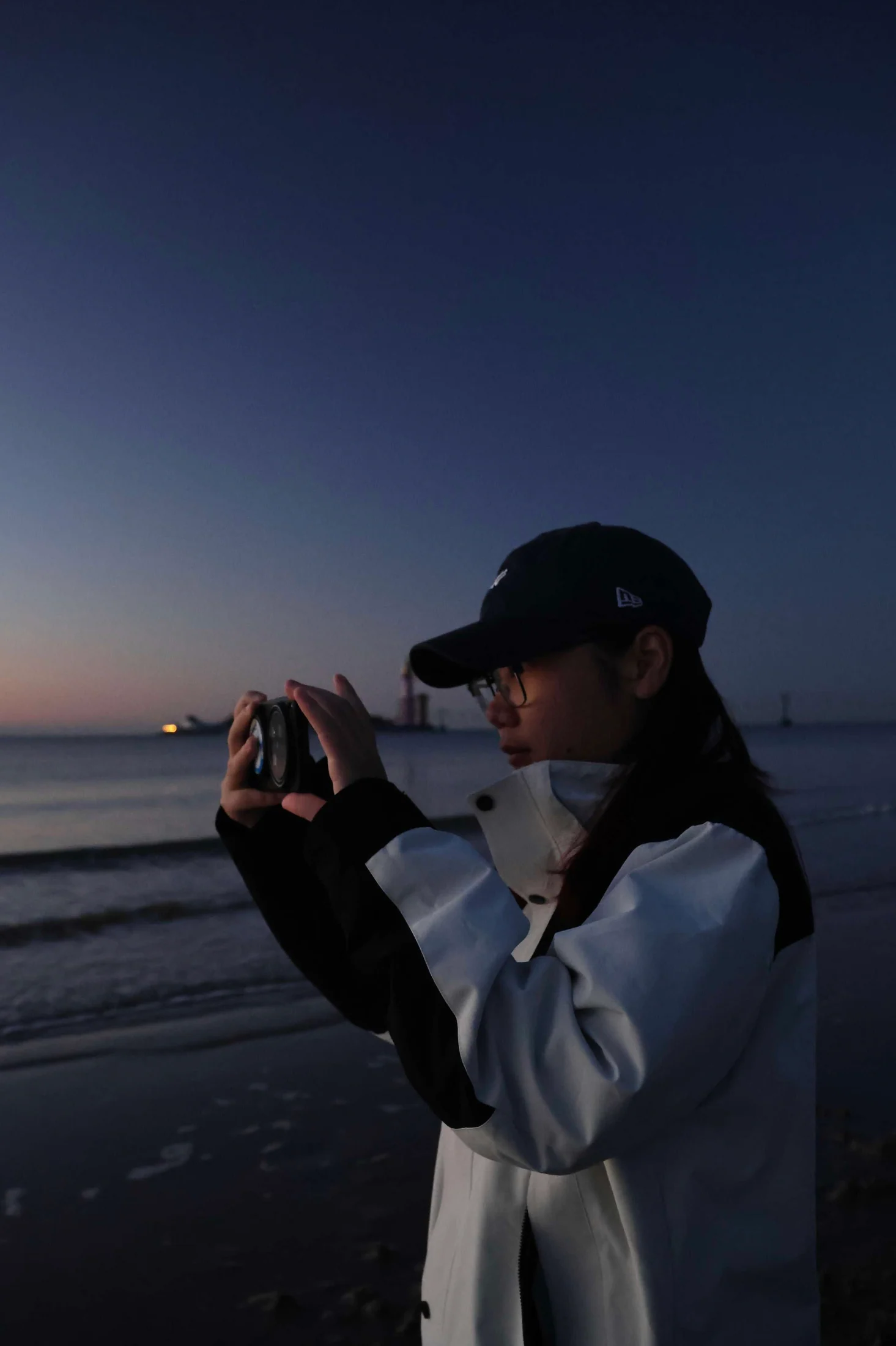 海边举起相机拍摄的同行者